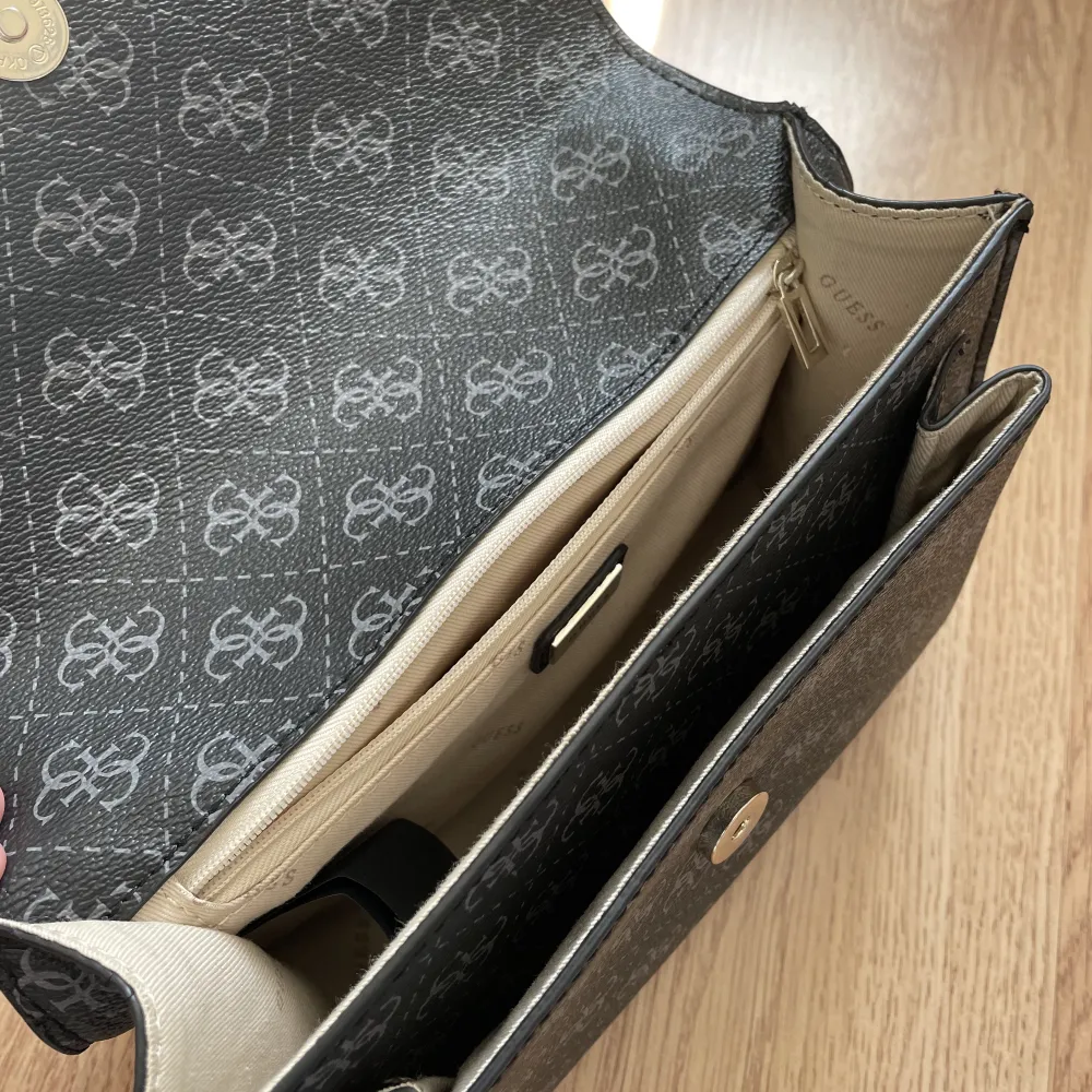 Säljer denna märkesväska från Guess i en grånyans med guld kedja. Kan skicka fler bilder vid förfrågan. Väskan är äkta. . Väskor.