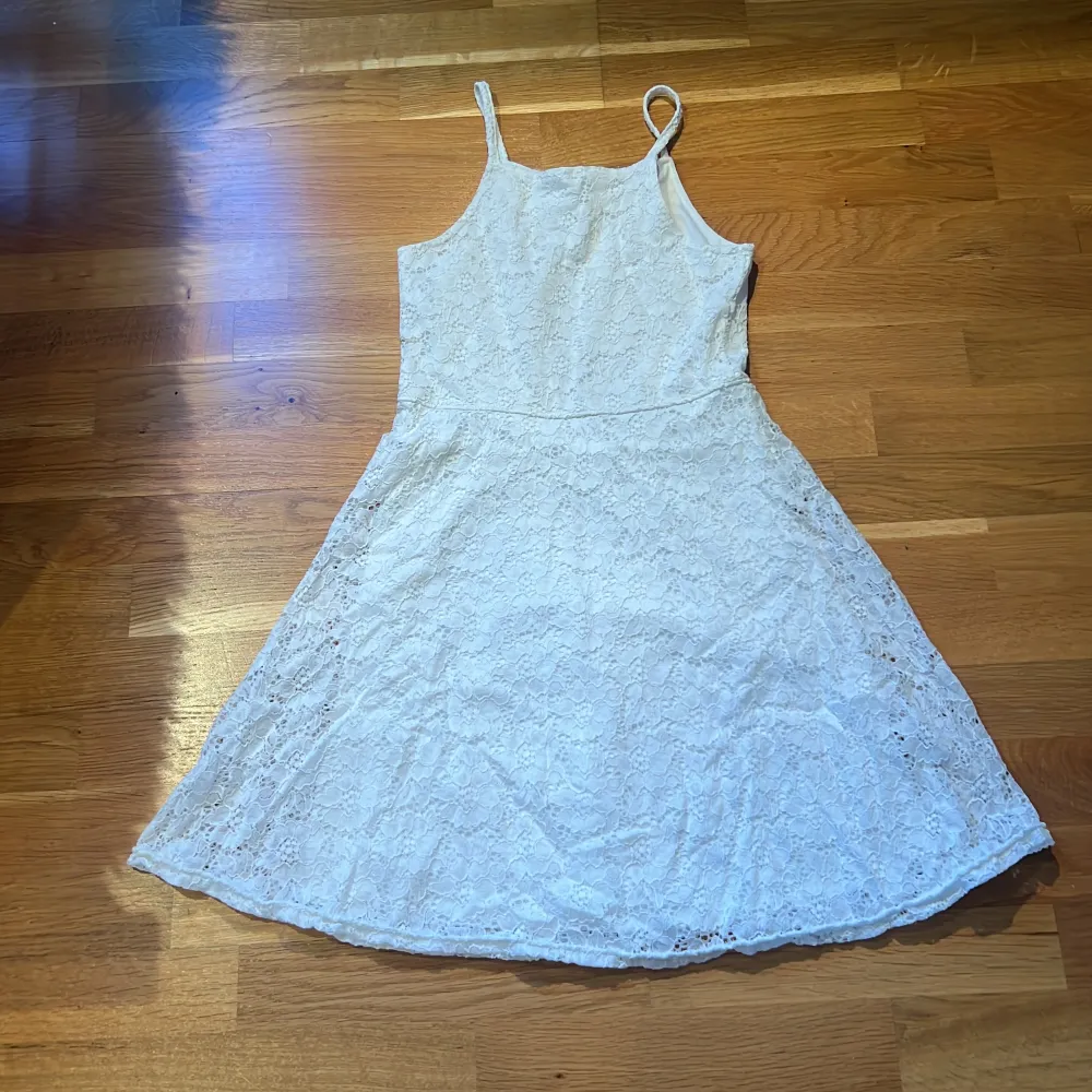 Det är en vit klänning med lite blomm aktigt mönster, original priset är 250 och är inte så använd. Silkes tyg inuti så dem är skön mot kroppen. . Klänningar.