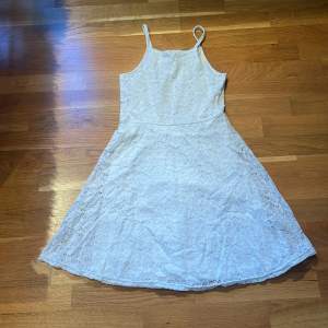 Det är en vit klänning med lite blomm aktigt mönster, original priset är 250 och är inte så använd. Silkes tyg inuti så dem är skön mot kroppen. 