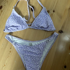 Bikini från shein - Bikini från shein. Lila med vita blommor och lite detaljer på underdelen. Aldrig använd.