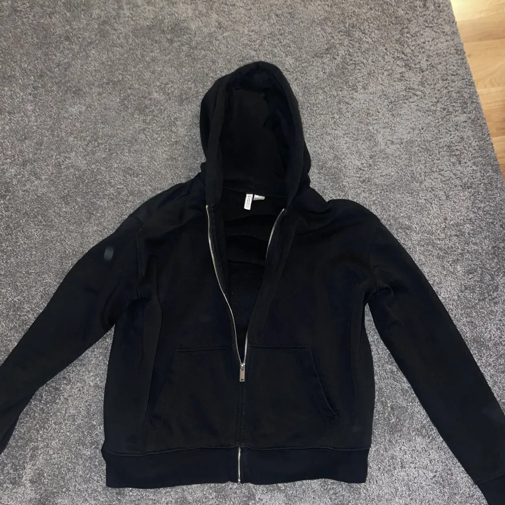 En svart zip hoodie från h&m. Lite kortare i längden. Köptes på h&m i Umeå.. Tröjor & Koftor.