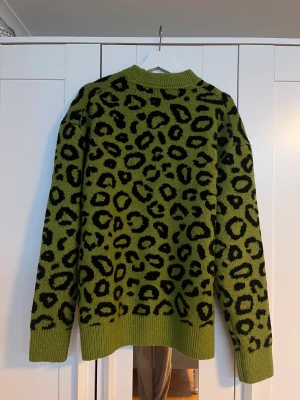 Grön Leopardtröja - Stickad grön tröja med leopardmönster. Finns inga hål eller fläckar. Har använts fåtal gånger då den nästan aldrig har kommit till användning. 