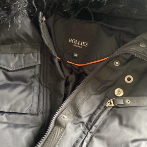 Hollies jacka - Säljer min fina hollies jacka strl 34. Använd några gånger. Väldigt fint skick. Pälsen är inte äkta men ser dock mycket äkta ut . Går även att ta bort pälsen