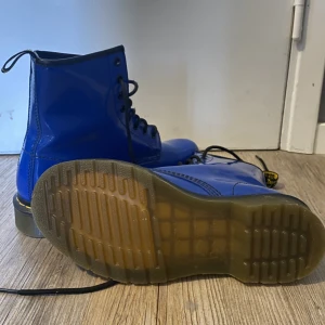Blåa Dr.Martens - Säljer dessa Dr.Martens åt min mamma då dem tyvärr var försmå på henne & förstora på mig. Dom är aldrig använda, endast testade, därav är dom i nyskick!  Pris kan diskuteras! Nypris 2100kr