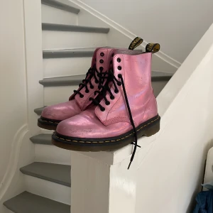 Rosa Dr Martens kängor  - Välanvända så en del slitningar i skinnet men ser fortfarande fina ut, st 39! De är metallic så de glänser. Nypris ca 1700kr