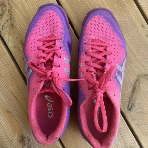 Asics Inneskor  - Asics inneskor för gymmet, idrotten eller inomhussporten. Mycket bra skick enbart andvända ett fåtal gånge. Superfina i lila & rosa.