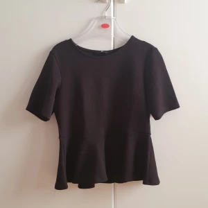 Svart topp - Oanvänd peplum topp från HM.