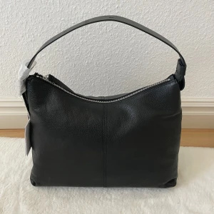 Axelremsväska  - Helt oanvänd svart axelremsväska från and other stories. Nypris 1500kr. 