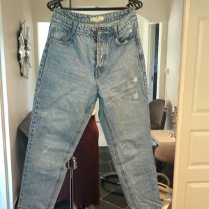 Jeans  - Snygga jeans med uppradade knappar framtill, utan dragkedja. Vita mindre slitna detaljer. 