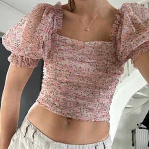 Rosa blommig blus  - Blommig blus från H&M, den är smockad så sitter snyggt och skönt! Använda ca 2 gånger.