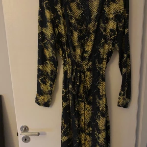 Klänning - Midi klänning mönstrad med knyt i midjan 