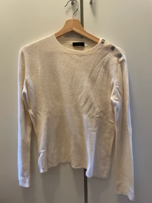 Tröja  - Långärmad tröja med knappar på sidan av axeln 