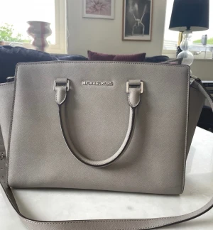 Mk väska  - Grå. Mycket fint skick 32x25 cm. Axelband finns. 