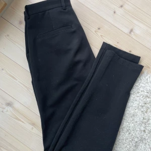 Svarta Kostymbyxor - Jättefina kostymbyxor i mycket bra skick. Dock saknas en knapp och därav säljer jag dom lite billigare, i övrigt inga skador eller slitningar. Nypris ca 1000 kr. Oklar stl men jag är 186 cm lång och brukar ha W29/30.