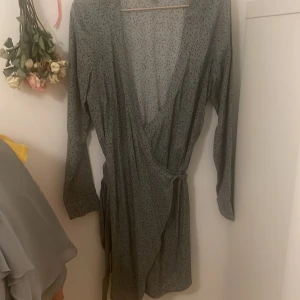 Omlott klänning  - Omlottklänning med snörning i grön och svarta prickar från hm 