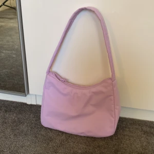 Lila Axelväska  - En lika axelväska från Gina tricot. Är i ganska bra skick men använd några gånger. Jättefin väska till sommaren!