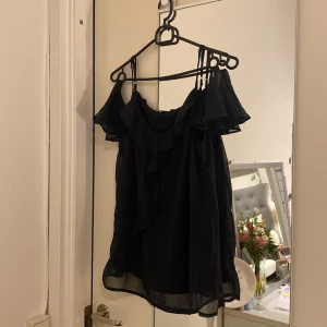 Blus med volangärm - Jätte fin marinblå blus med en volangdetalj på ärmen med öppen Axeln samt över bysten! Jätte fint skick