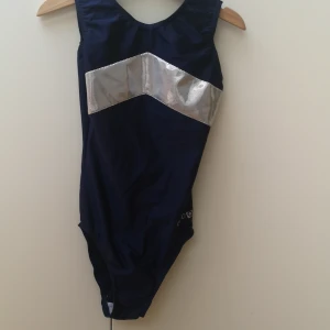 Gymnastikdräkt  - En tävlingsdräkt som är i bra skick med fina glittriga detaljer, det står tyvärr ingen storlek i dräkten men den passar en tjej i 10-12års åldern. 