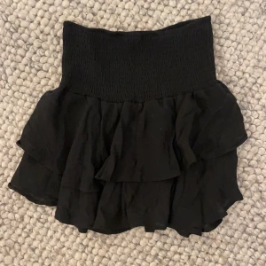 Kjol  - Svart volangkjol, endast använd en gång! Högmidjad men går att vika ned för att få lågmidjad (se bild 3). Pris kan diskuteras🥰 Skriv vid intresse!