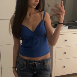 blått linne y2k - ett blått linne med spets på kanterna 🙌🏻🙌🏻den är lite längre irl, har vikt upp den lite på bilderna 🤍