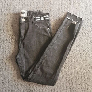Svarta jeans  - Skit snygga jeans med designfulla detaljer. Den är i nyskick och kom ej till användning. Mått för jeans är 88cm på längd, 64cm i inre ben och 33cm i midja.