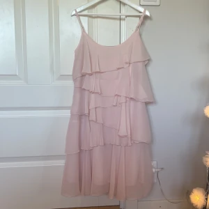 Ljusrosa volang klänning - Jätte fin rosa volangklänning från märket zoul🌸Storlek 32 men skulle även kunna passa som 34. Säljer den då jag aldrig använder den (ny skick). Pris går att diskutera
