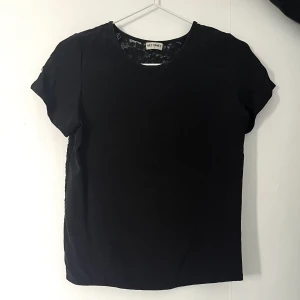 Svart t-shirt  - Cool svart t-shirt! Baksidan är helt i spets som man kan se på sista bilden! 
