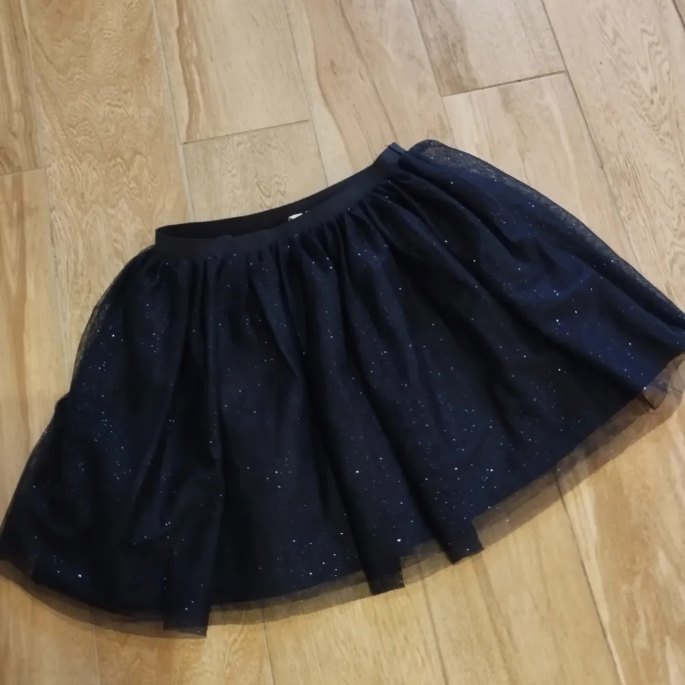 En fin mörkblå glittrig kjol för barn!  Låt ditt barn känna dig som en prinsessa för ett billigt pris.  Använd men i mycket bra skick.  Storlek: 122/128 6-8Y. Kjolar.