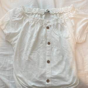 Fin vit blus med knappar. Knapparna är bara en dekoration så tröjan går inte att öppna. Använd 2-3 ggr och säljs då den inte kommer till användning längre.