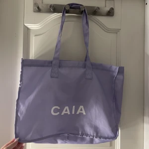 Caia väska/totebag! - En lila Caia väska/totebag! Se sista bilden för att få en bättre storleksbild, finns små fläckar men som säkert går bort i tvätten (Skriv privat så skickar jag bilder)! Tänker mig runt 200kr + frakt annars bud 💜