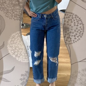 NA-KD, RIPPED mom jeans - HELT NYA! I ny skick, inga skador eller fläckar. Är uppvikta, så man kan vika ner dem som vanligt. Passar någon runt 150-165 cm. Vid frågor eller fler bilder kontakta!