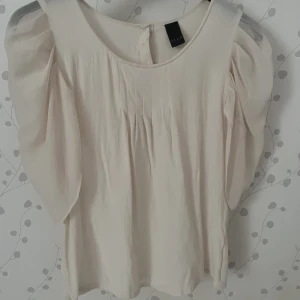 Ljusrosa/beige blus💘 - Så fin ljusrosa/beige blus från Vila i storlek S. Armarna är lite ”puffade” och i ryggen är de tre knappar🩷