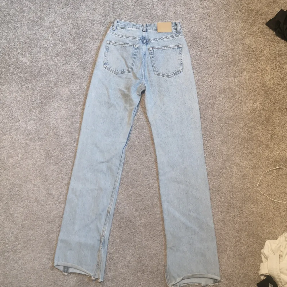 Supersnygga straight-jeans med hål vid knäna och slits vid slutet av benet. Helt oanvända i storlek 32.. Jeans & Byxor.