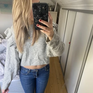 Grå stickad med volang - Säljer denna supersnygga stickade tröja med volangärm från H&M. Den är i storlek M men passar S. Hör gärna av vid intresse 💕💕