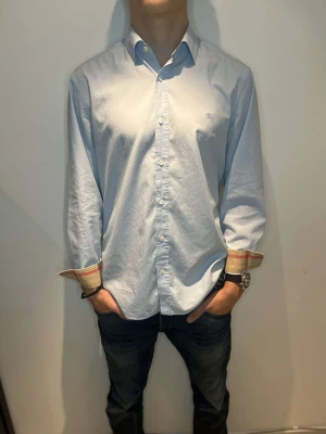 Burberry skjorta - Ljusblå Burberry skjorta Storlek: M passar S Skick: 8/10 Nypris:5600kr, vårt pris:1299kr 💫