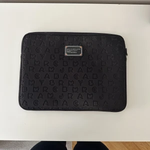 Marc Jacobs datorfodral - Jättefint Marc Jacobs datorfodral. Använt men inga defekter utöver att ”skylten” blivit lite bronsfärgad. 