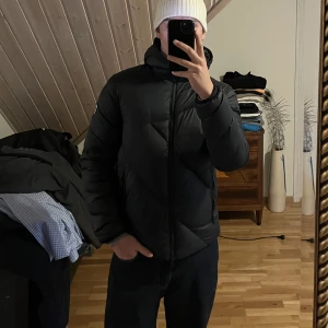 EA7 Jacka - Fin svart vinterjacka från EA7! Otroligt varm och skönt dunjacka med luva.  Storlek: M Nypris: 4099 kr Pris: 1500 kr eller bud.  Köparen står för frakten, tveka inte om ni har frågor eller ett bud på jackan.