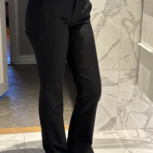 Lågmidjad kostymbyxor  - Lågmidjad kostymbyxa med slits längst ner.