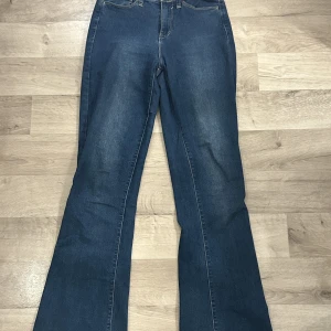 Bootcut jeans  - Mörkblå bootcut jeans ifrån fashionnova, jeansen är gjorda av ett stretchigt material och är lite slitna längst ned. 