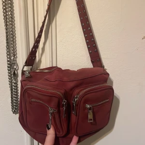 Väska - En röd väska från Noella från någon här på Plick. Knappt använd och är i bra skick. (Finns ett långt rött band som man får med)