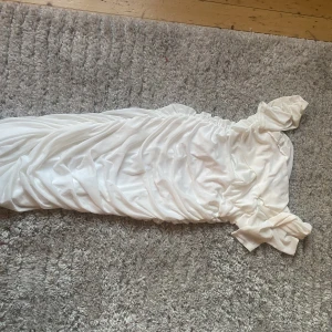 Klänning - Vit klänning, som har använts 1 gång. Från bohoo. Den är skrynklad och har väck över magen och bysten samt ryggen och rumpan. 