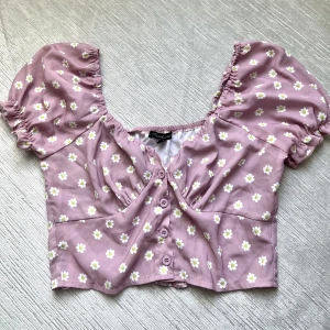 Blomming rosa crop - Jätte fin cropped blommig rosa/lila blus. Perfekt för sommaren! Använd en gång. 