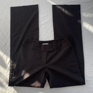 Lågmi kostymbyxor pinstripe  - Skitsnygga kostymbyxor med pinstripe mönster. Low waist och raka/vida ben. Storlek 34. Bra skick, inga defekter. Midja 36x2, Innerbenslängd 79, Benöppning 23 (cm). Önskar verkligen att de passade mig. Köps via Swish eller köp nu 💋