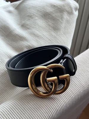 Oanvända Gucci bälte - storlek 80 cm - Säljer mitt Gucci bälte, modell Leather belt with double G buckle - storlek 70 cm.  Jättefint bälte men ångrade köp.   Spännet är 4x3 cm  Inköpt från Guccis hemsida, kvitto finns. 