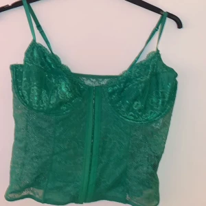 Korsett topp - grön - Jag köpte denna snygga fest topp från Gina Tricot, i storlek M. Tyvärr är den aldrig använd då den var för stor för mig. Skulle kalla den ”stor i storleken.” Annars är det en sprillans ny fest topp.