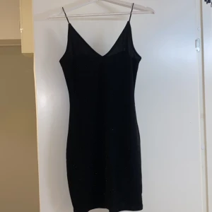 Glittrig klänning  - Svart glittrig klänning. Använd 1 gång 