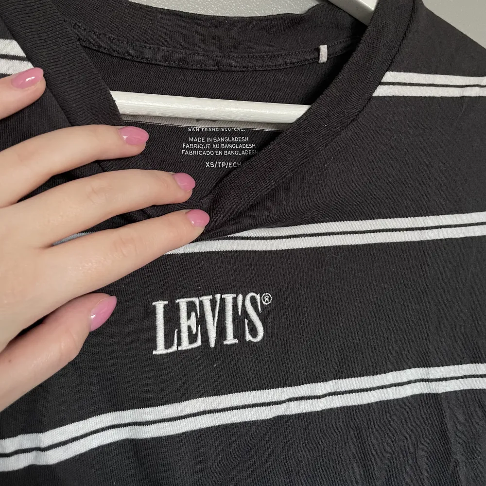 T-shirt från Levis i strl xs. Mörkgrå och vitrandig. Lite kortare i modellen. Blivit för liten för mig men i väldigt bra skick!. T-shirts.