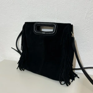 Maje väska nästan aldrig använd - Svart väska i mocka från Maje. Använd färre än 3 gånger, därav jättefint skick även inuti. Cirka 25 x 23 cm. Dustbag och påse medföljer.