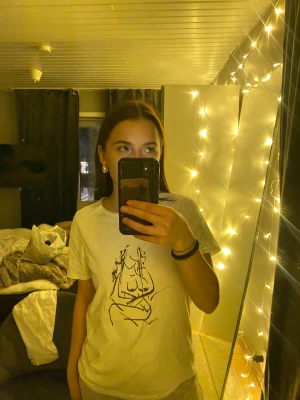 T-shirt med tryck  - En vit t-shirt med ett svart kvinnligt tryck på. Knappt använd alls. Köpt för ca 200:-. Pris kan diskuteras. 💕