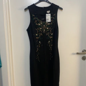 Klänning oanvänd HM  - Oanvänd klänning med prislappen på, svart med stenar , armlös 